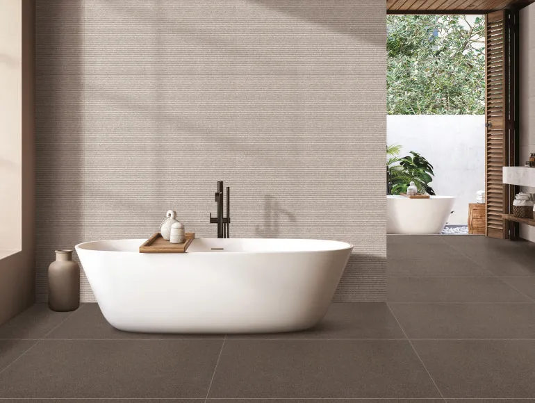 White bathtub in beige bathroom design featuring Sahara Choco tiles and a large window